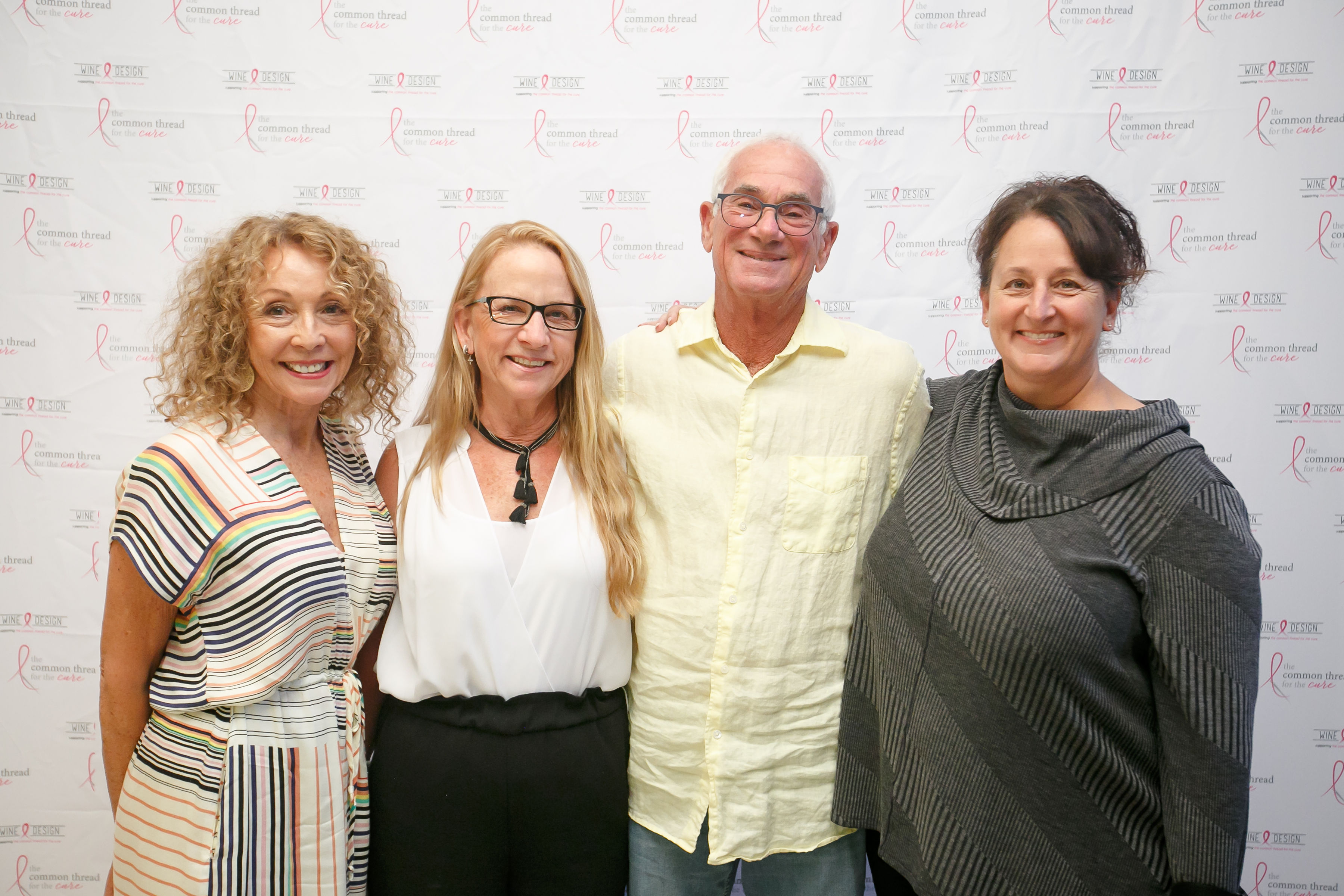 four people in front of step and repeat